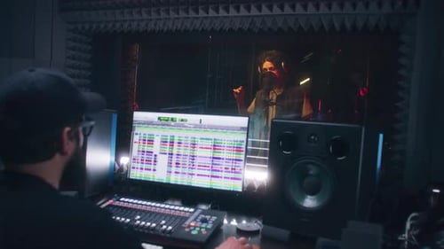 Audio Engineer Works with Male Singer in Recording Studio