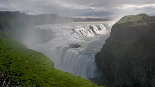 Majestic Waterfall Cascading Over Rocky Cliffs in Icelands Stunning Landscape