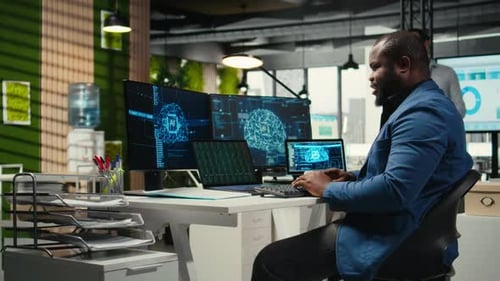 Man Typing at Computer in Modern Urban Office