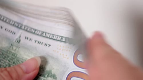 Close up of female hands counting 100 American dollars in white background