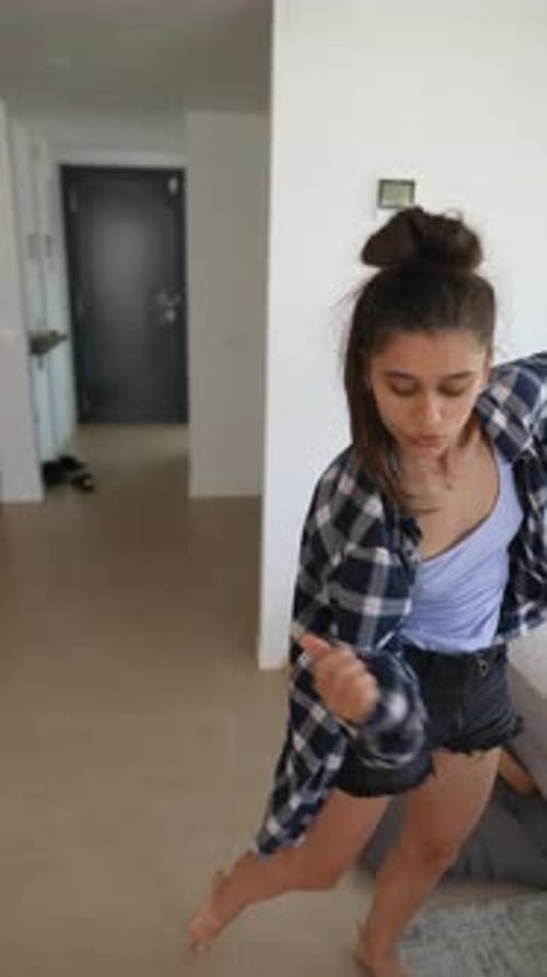 Young Adult Dances Barefoot in Bright Modern Living Room