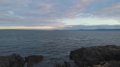 Serene Coastal Sunset: Calm Ocean Waves, Rocky Shore. British Columbia, Canada.