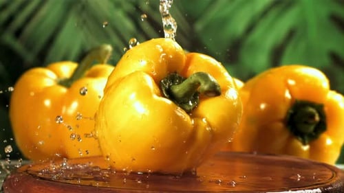 Fresh Yellow Bell Peppers Being Sprinkled with Water