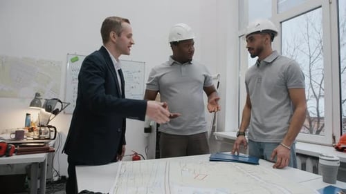 Manager Shaking Hands with Engineer during Discussion in Construction Office