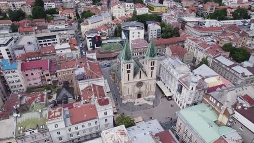 Aerial: Sarajevo's Sacred Heart Cathedral amidst urban landscape. Bosnia