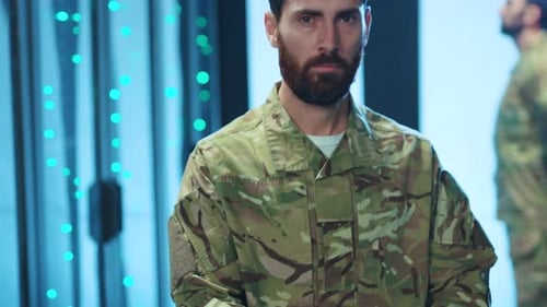 Man in camouflage uniform standing in server room