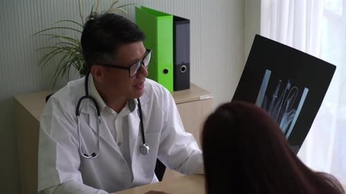 Doctor Reviews X-Ray with Patient in Office