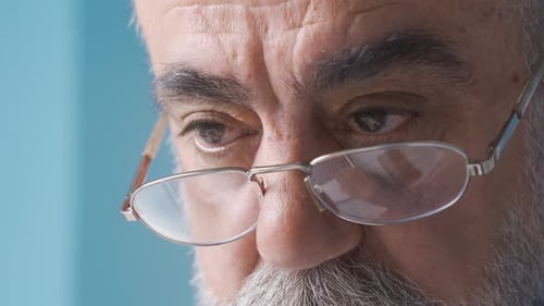 Close-up eyes of old man with glasses.