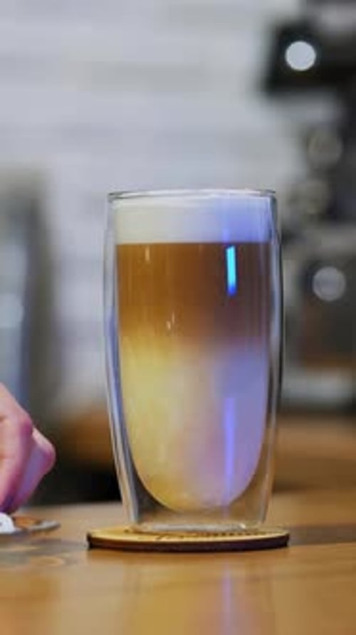 Serving beverage. Tasty dessert on the table. Woman puts straw into a glass of fresh drink