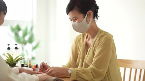 Woman Doing Manicure in Bright Indoor Salon