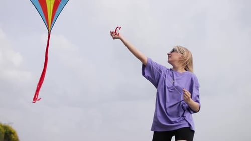 Woman Flies a Kite on Bright Day