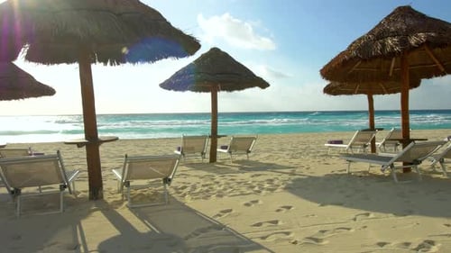 White sand beach with blue ocean waters and empty chairs on a tropical island