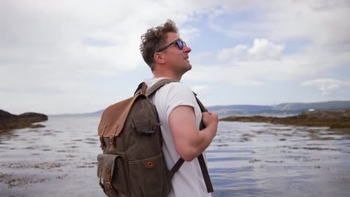 Man with a Backpack on the Beach Portrait of a Guy with a Backpack in Glasses on the Beach