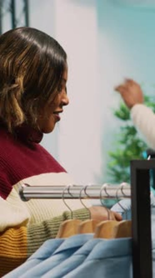 Vertical Video Asian Employee Showing Clothes to Customer in Retail Shop