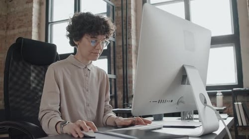 Junge Frau tippt im Büro auf der Tastatur