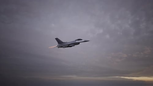 Un avión de combate con postcombustión encendida en un cielo nublado