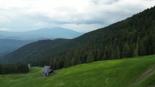 Mountains during a cloudy day with mountains peaks, forest, lush greenery and trees - drone 4K