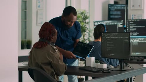Développeur de base de données expliquant l'algorithme à un collègue codeur pointant du doigt le code en cours