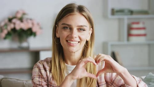 Smiling Woman Makes Heart Shape With Hands
