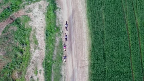 Horseback riding in a green Badlands terrain, aerial footage