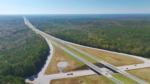 View From Above of Busy American Highway with Fast Moving Traffic Between Woods