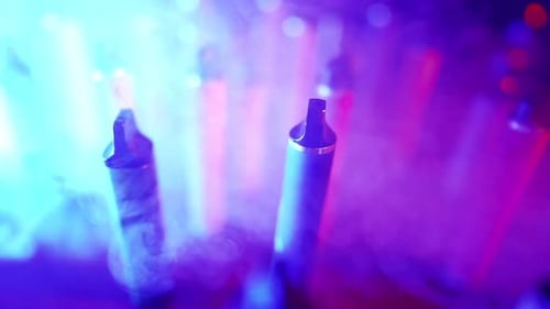 Vape Pens in a Smoky, Colorful Nightclub