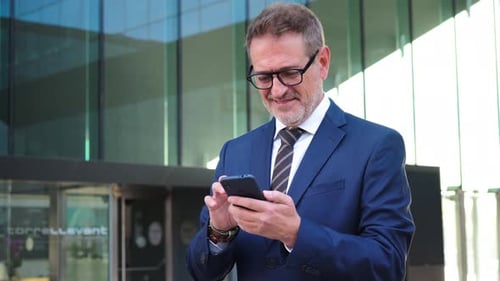 Business Man Using Smartphone Outside Office Building