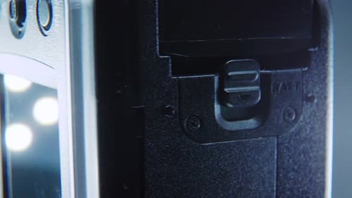 A macro close up shot of a video camera, silver camcorder on a 360 rotating stand, studio lighting,