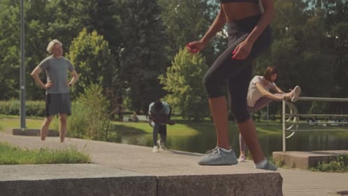 Woman Exercising in Urban Park with Workout Group
