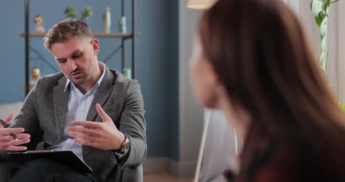 Adult Man Talking to Female Patient in Office