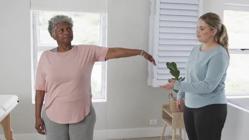 Senior Woman Exercises with Physical Therapist Indoors