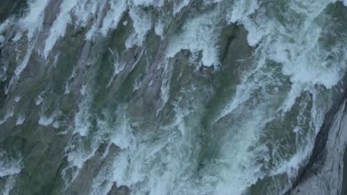 Vue d'en haut montrant la puissance de l'eau vive d'une rivière et d'une cascade.