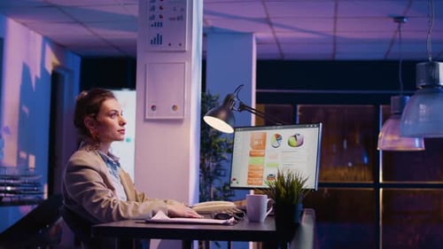 Woman in Office Working Late at Computer
