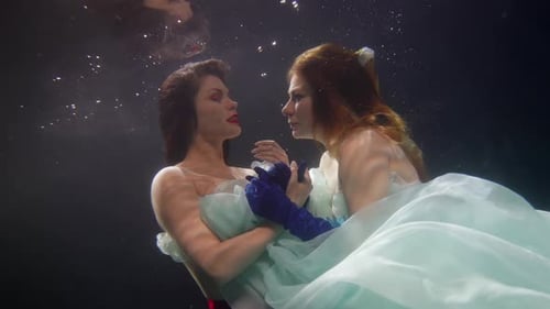 Elegant Women in Flowing Fabric Underwater