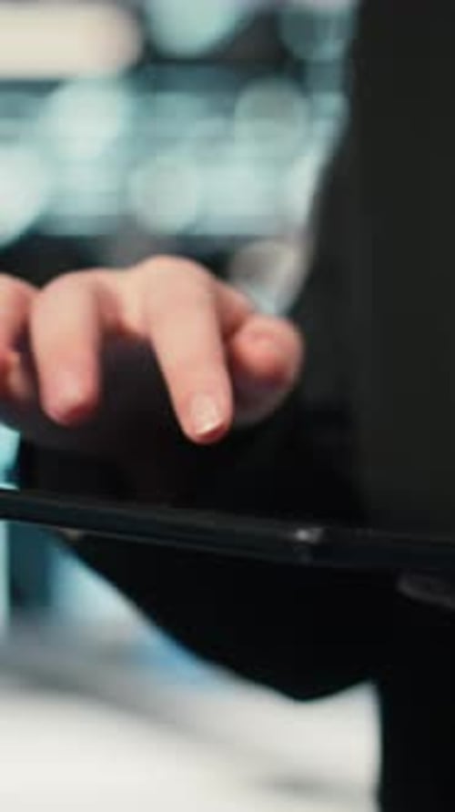 Vertical Video Close Up of Data Center Cybersecurity Analyst Using Tablet to Conduct Audit