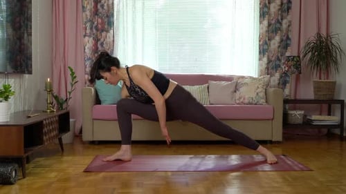 Woman Does Yoga Poses on Mat Indoors
