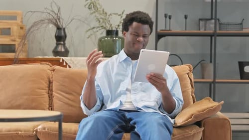 Young Adult Using Tablet While Sitting on Couch