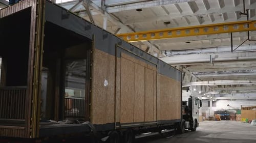 Modular Home Loaded Onto Truck Inside Manufacturing Facility