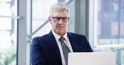 4k video footage of a mature businessman working on a laptop in an office