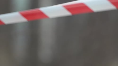 Fita de advertência vermelha e branca balançando no sinal de proteção contra o vento Não cruze a linha vermelha e branca