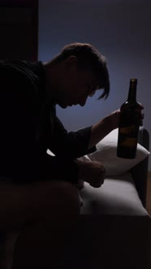 Young Man Sitting and Drinking Wine Indoors