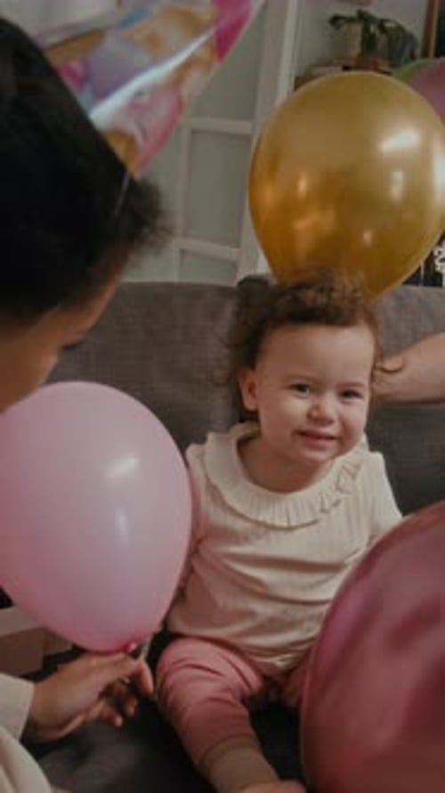 Family Celebrates Baby's Birthday With Balloons at Home