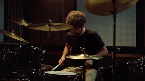 Upset Artist Playing on Drum Kit in Recording Studio. Disappointed Male Drummer