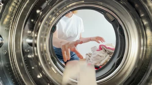 Point of View From Inside a Washing Machine As a Young Woman in Casual Clothes Loads Laundry Modern