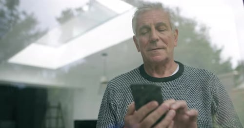 Senior Man Using Mobile Phone Indoors