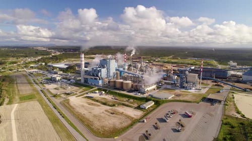Aerial wide shot of a big industrial plant on a sunny day - bird's eye view of a modern cellulose fa