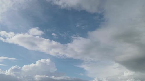 Fluffy Clouds Drifting Across Blue Sky