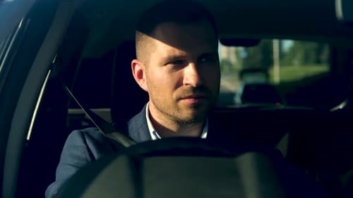 Young Caucasian Man Driving the Car Sun Rays Shining Through the Windshield Right Hand Drive Car