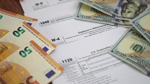 Formulaires fiscaux contenant des billets en dollars et en euros éparpillés préparant des rapports détaillés pour les clients