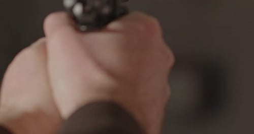 Hand firing a 9mm handgun with heavy recoil in slow motion